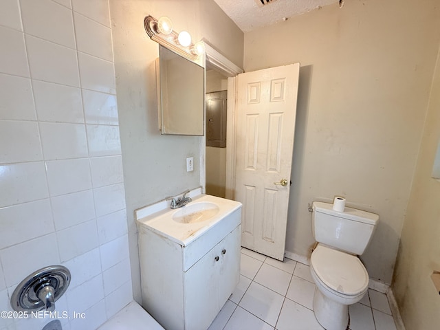 bathroom with a textured ceiling, tile patterned floors, vanity, and toilet