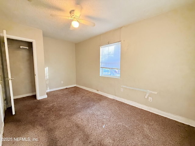 unfurnished bedroom with ceiling fan, a textured ceiling, and dark colored carpet