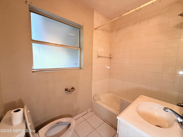 full bathroom featuring a textured ceiling, tiled shower / bath, tile patterned floors, sink, and toilet