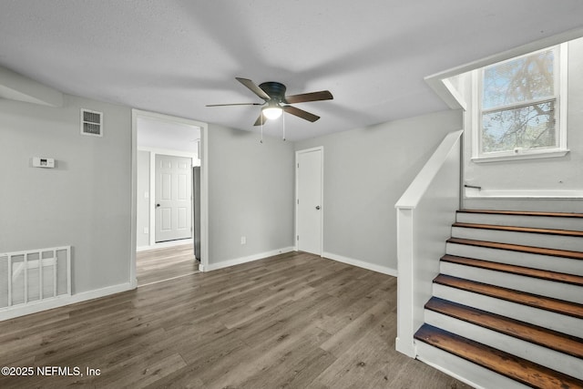 interior space with wood-type flooring, a textured ceiling, and ceiling fan