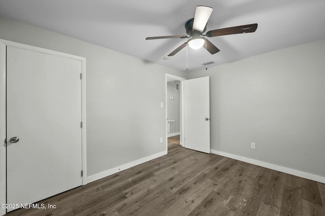 unfurnished bedroom featuring dark wood-type flooring and ceiling fan