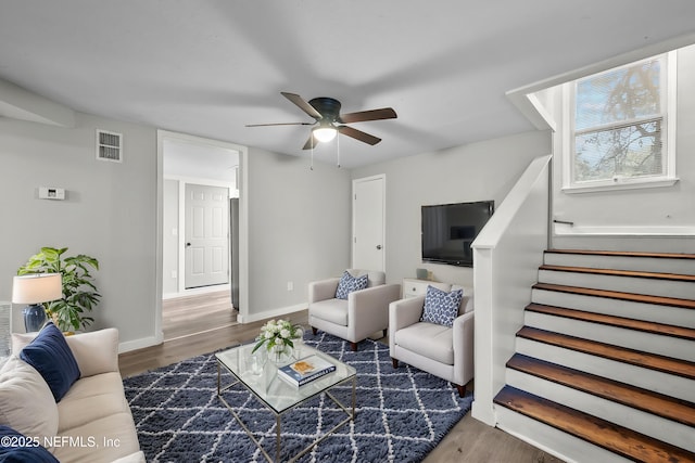 living room featuring dark wood-type flooring and ceiling fan