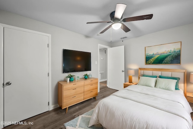 bedroom with dark hardwood / wood-style floors and ceiling fan