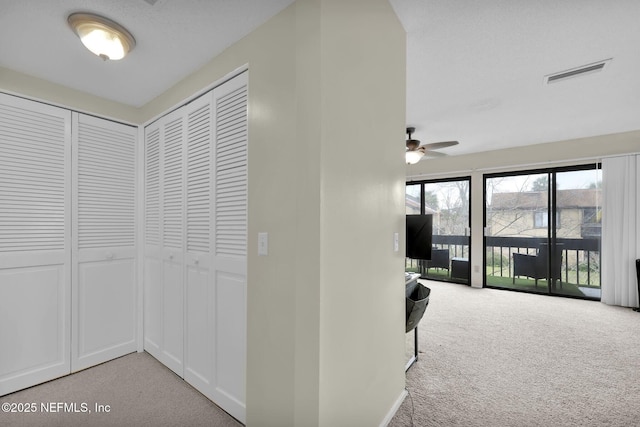 hallway featuring light colored carpet