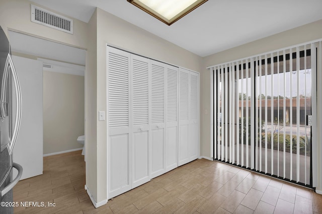 unfurnished bedroom with stainless steel fridge and a closet