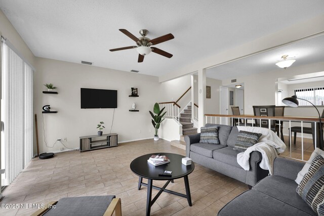 living room with ceiling fan and light hardwood / wood-style flooring