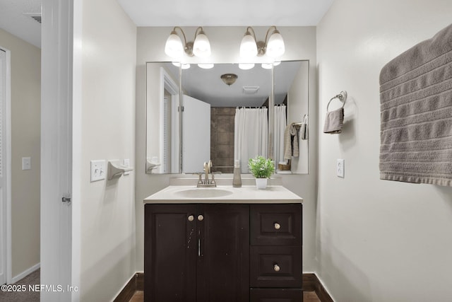 bathroom featuring walk in shower and vanity