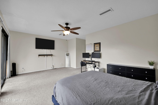 carpeted bedroom featuring ceiling fan and a textured ceiling