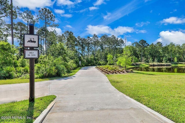 view of home's community featuring a lawn and a water view