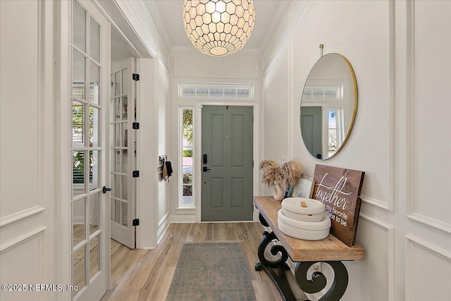 foyer featuring crown molding and light hardwood / wood-style floors