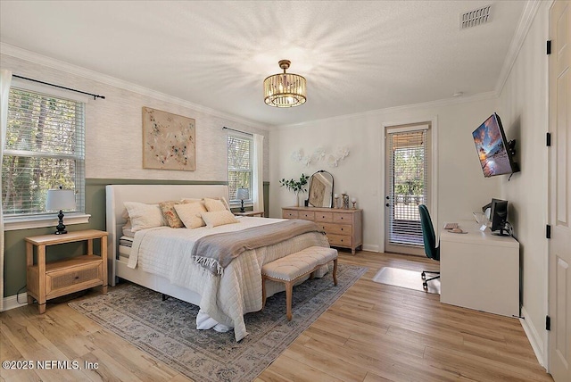 bedroom with ornamental molding, access to outside, a notable chandelier, and light hardwood / wood-style flooring