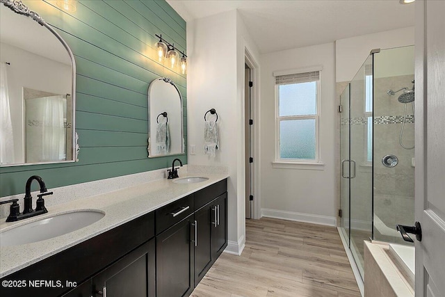 bathroom with vanity, a shower with shower door, and wood-type flooring