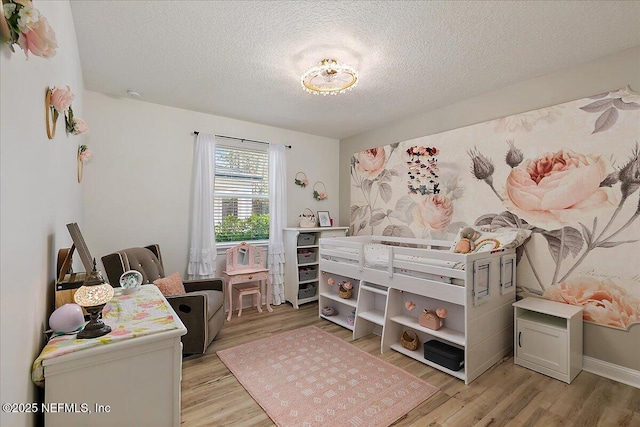 bedroom with a textured ceiling and light wood-type flooring