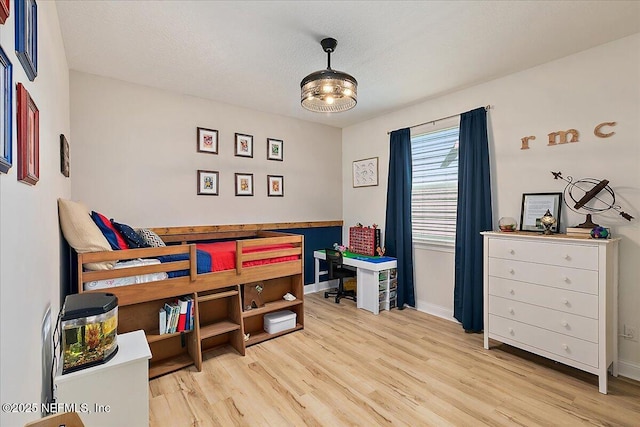 bedroom with a textured ceiling and light wood-type flooring