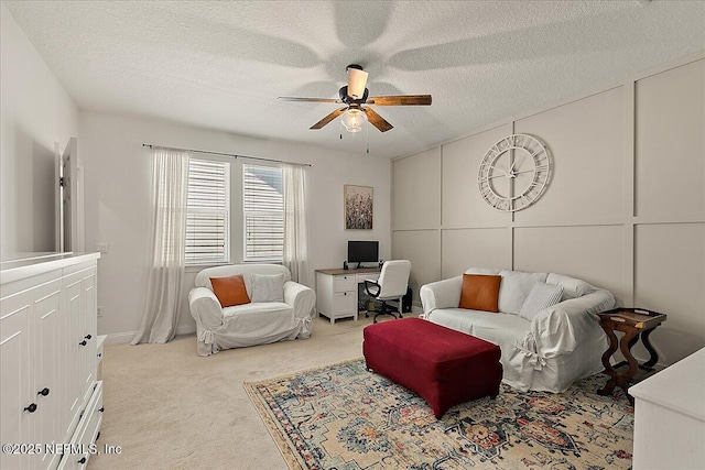 living room featuring ceiling fan, light colored carpet, and a textured ceiling