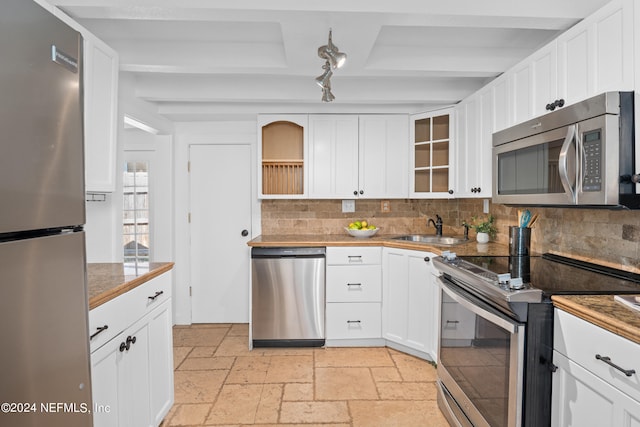 kitchen with sink, white cabinetry, appliances with stainless steel finishes, and decorative backsplash