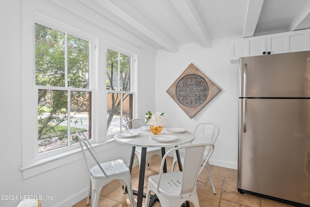 dining space with beamed ceiling