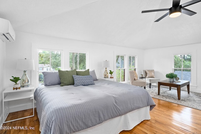 bedroom featuring ceiling fan, hardwood / wood-style flooring, and multiple windows