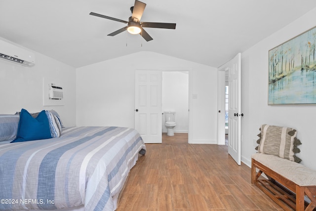 bedroom with wood-type flooring, ensuite bath, an AC wall unit, and ceiling fan