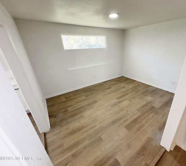 unfurnished room with hardwood / wood-style flooring