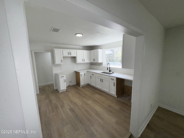 kitchen featuring light hardwood / wood-style floors, sink, and white cabinetry