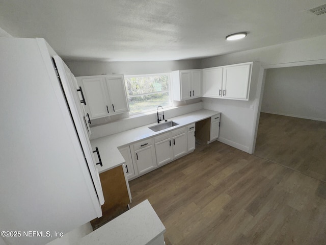 kitchen with sink, white refrigerator, dark wood-type flooring, and white cabinetry