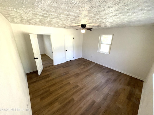 unfurnished bedroom with ceiling fan, dark wood-type flooring, and a textured ceiling