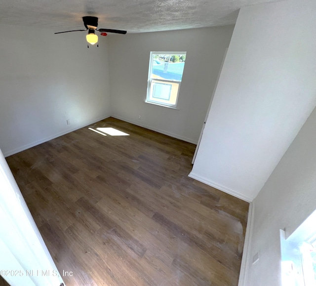 unfurnished room featuring ceiling fan, dark hardwood / wood-style floors, and a textured ceiling