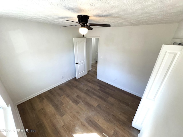 spare room with ceiling fan, dark wood-type flooring, and a textured ceiling