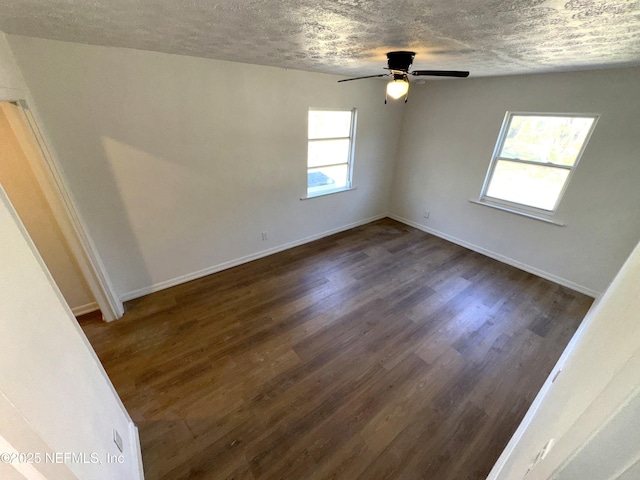 spare room with a textured ceiling, dark hardwood / wood-style floors, and ceiling fan