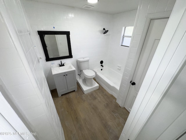 full bathroom featuring tiled shower / bath combo, hardwood / wood-style flooring, toilet, and vanity