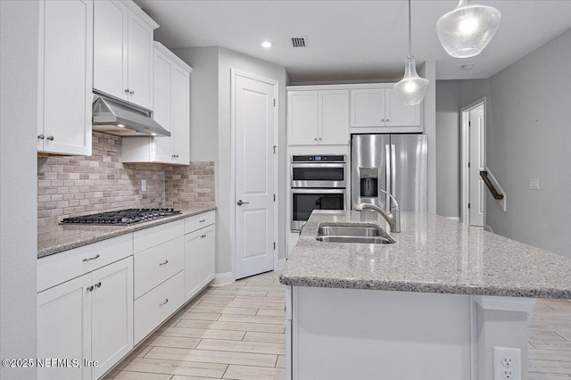 kitchen featuring white cabinetry, pendant lighting, an island with sink, and appliances with stainless steel finishes