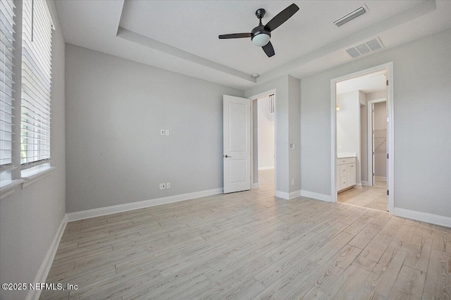 unfurnished bedroom featuring connected bathroom, light hardwood / wood-style flooring, and ceiling fan