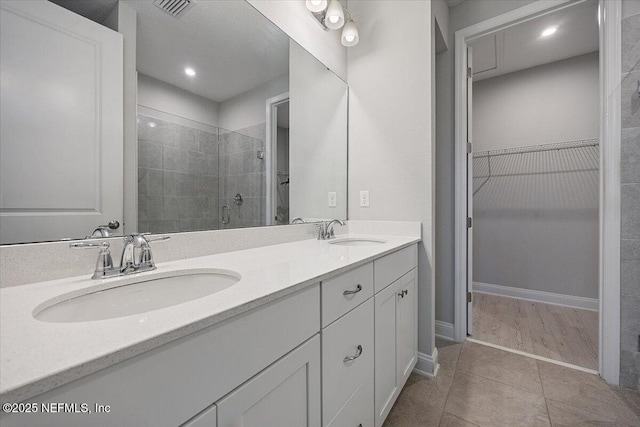 bathroom with vanity, tile patterned floors, and a shower with door