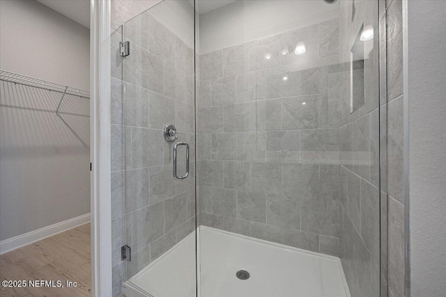 bathroom featuring wood-type flooring and an enclosed shower