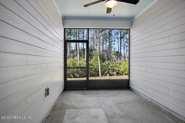 unfurnished sunroom with ceiling fan