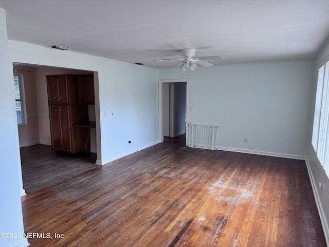 empty room with ceiling fan and dark hardwood / wood-style flooring