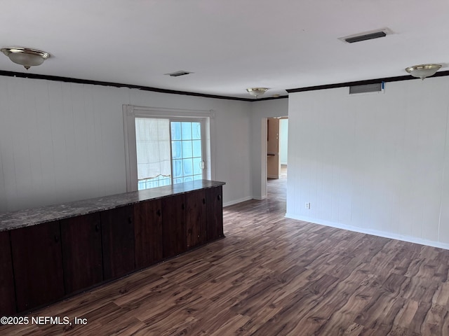 spare room with dark hardwood / wood-style flooring and crown molding