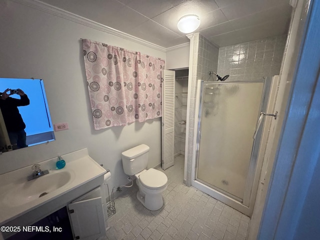 bathroom featuring vanity, a shower with shower door, crown molding, and toilet