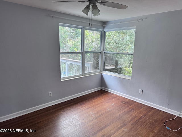 empty room with ceiling fan and dark hardwood / wood-style floors