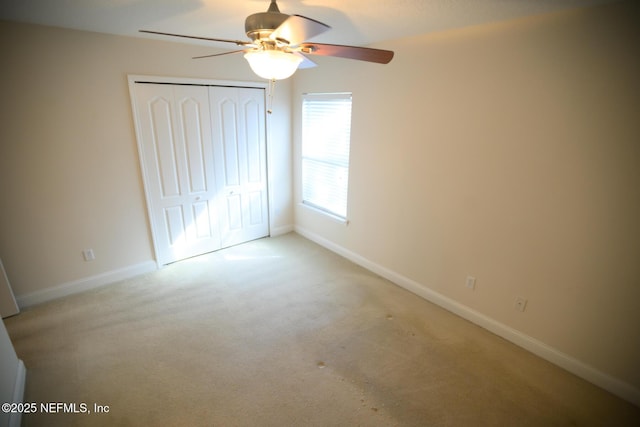 unfurnished bedroom with light carpet, a closet, and ceiling fan