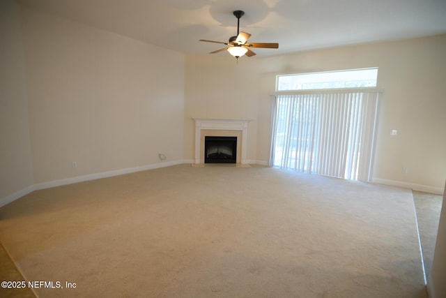 unfurnished living room featuring ceiling fan and light colored carpet