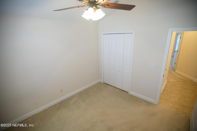 unfurnished bedroom with light carpet, vaulted ceiling, a closet, and ceiling fan