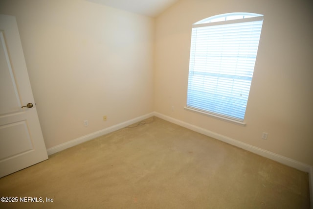 unfurnished room with vaulted ceiling and light colored carpet