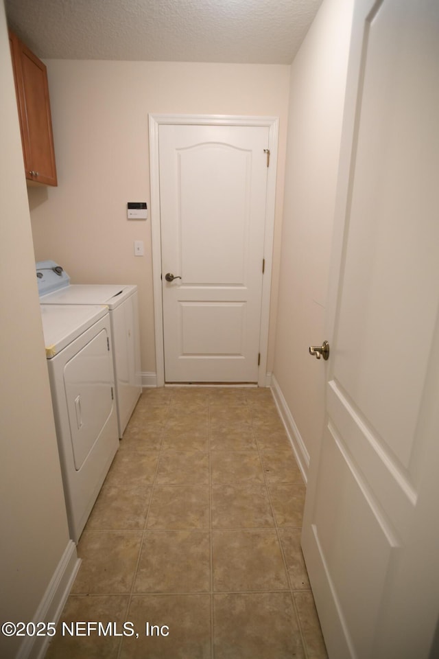 laundry area featuring cabinets, separate washer and dryer, and a textured ceiling