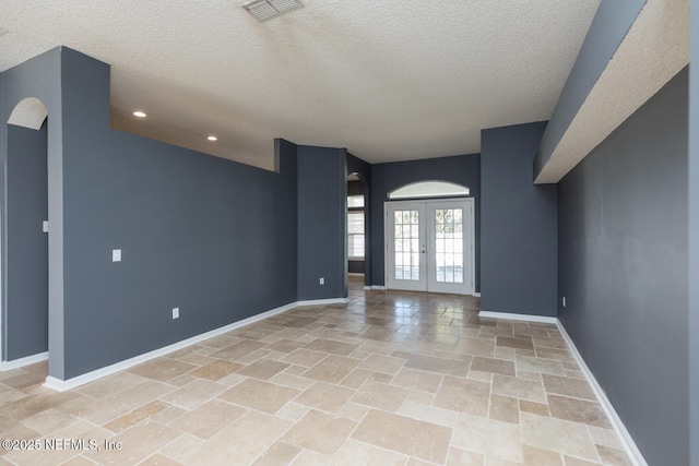 interior space featuring french doors and a textured ceiling