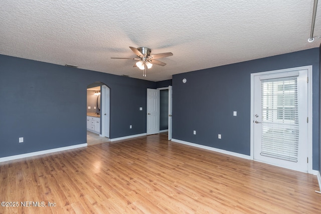 interior space featuring connected bathroom, ceiling fan, a textured ceiling, and light wood-type flooring