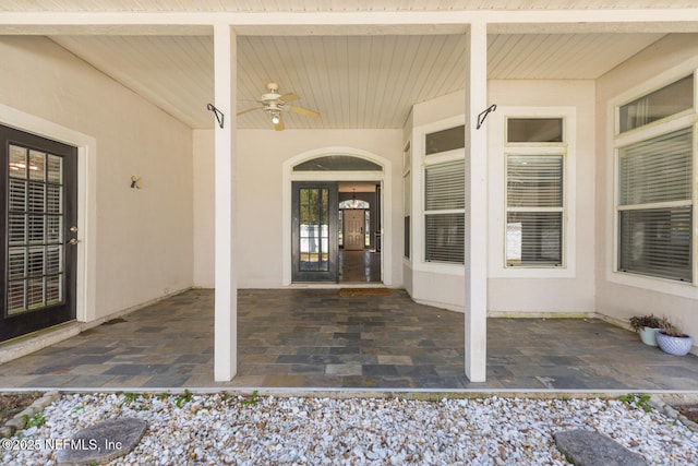 entrance to property with ceiling fan and a patio