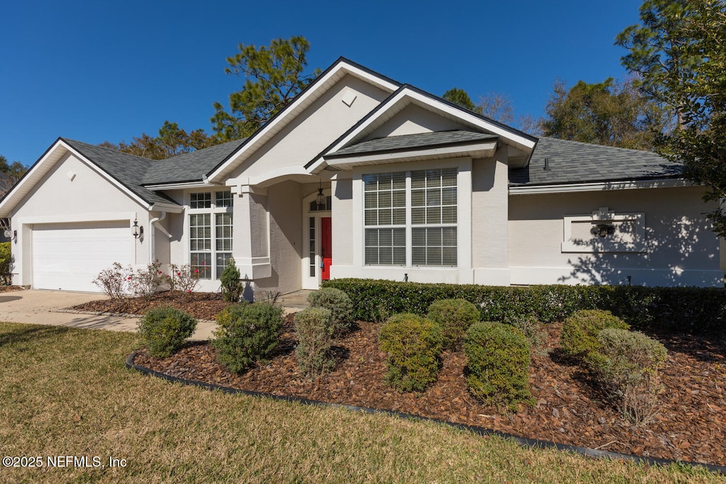 single story home featuring a garage and a front yard