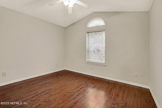 spare room with ceiling fan, lofted ceiling, dark hardwood / wood-style floors, and a textured ceiling